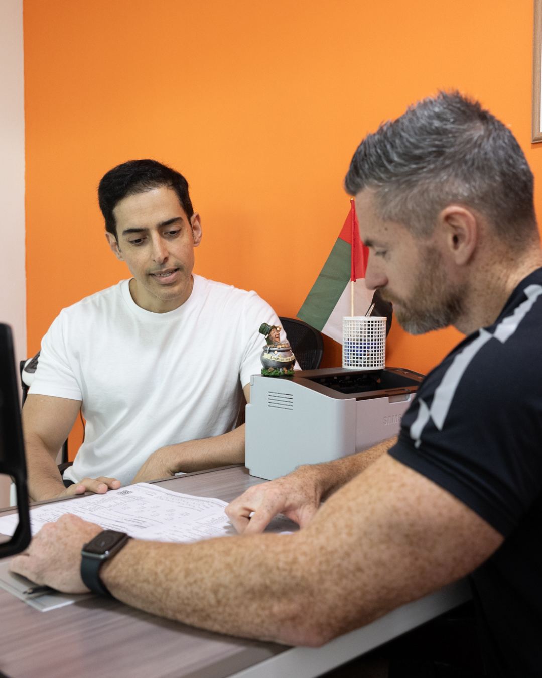 James Canning reviewing a client programme at Elite Fitness Abu Dhabi